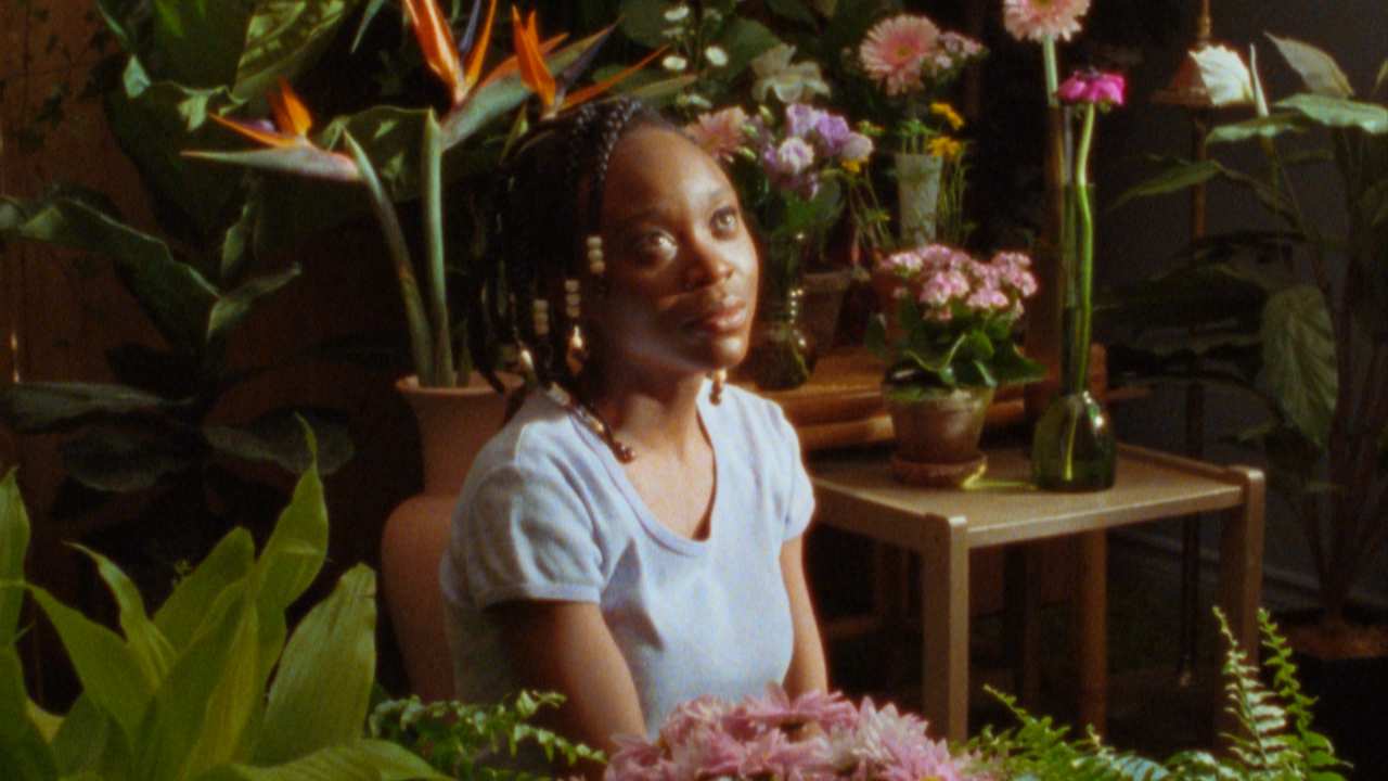 a woman surrounded by potted plants and flowers